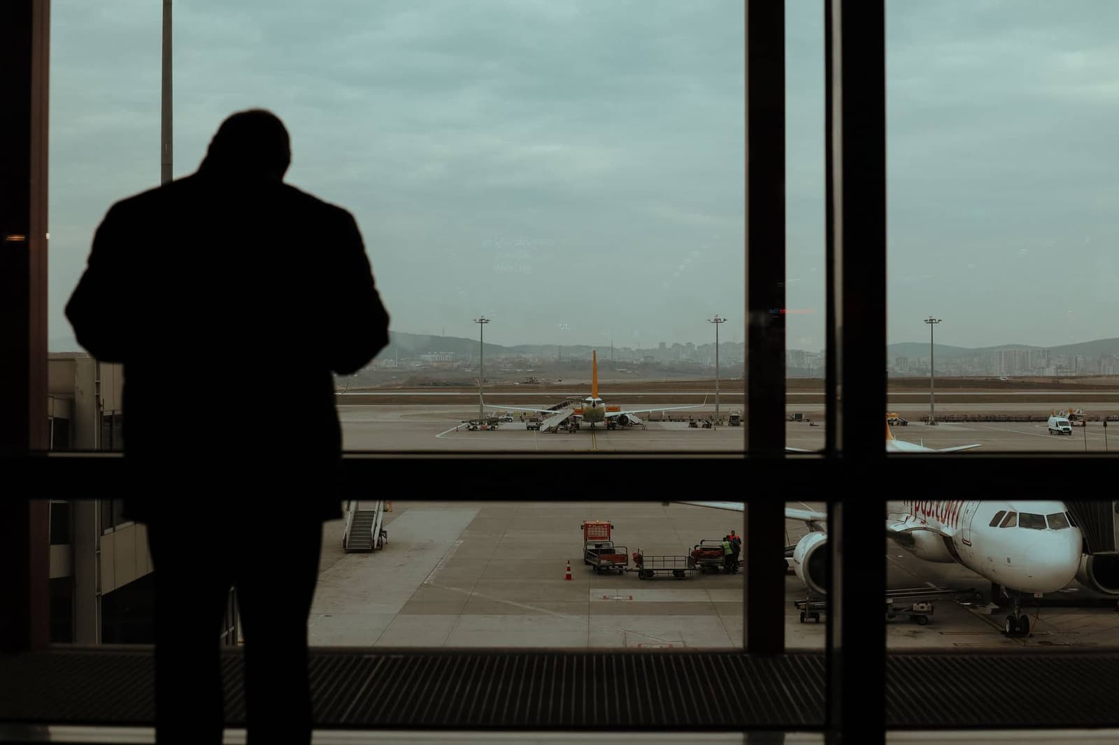 Voyageur devant la baie vitrée d’un aéroport